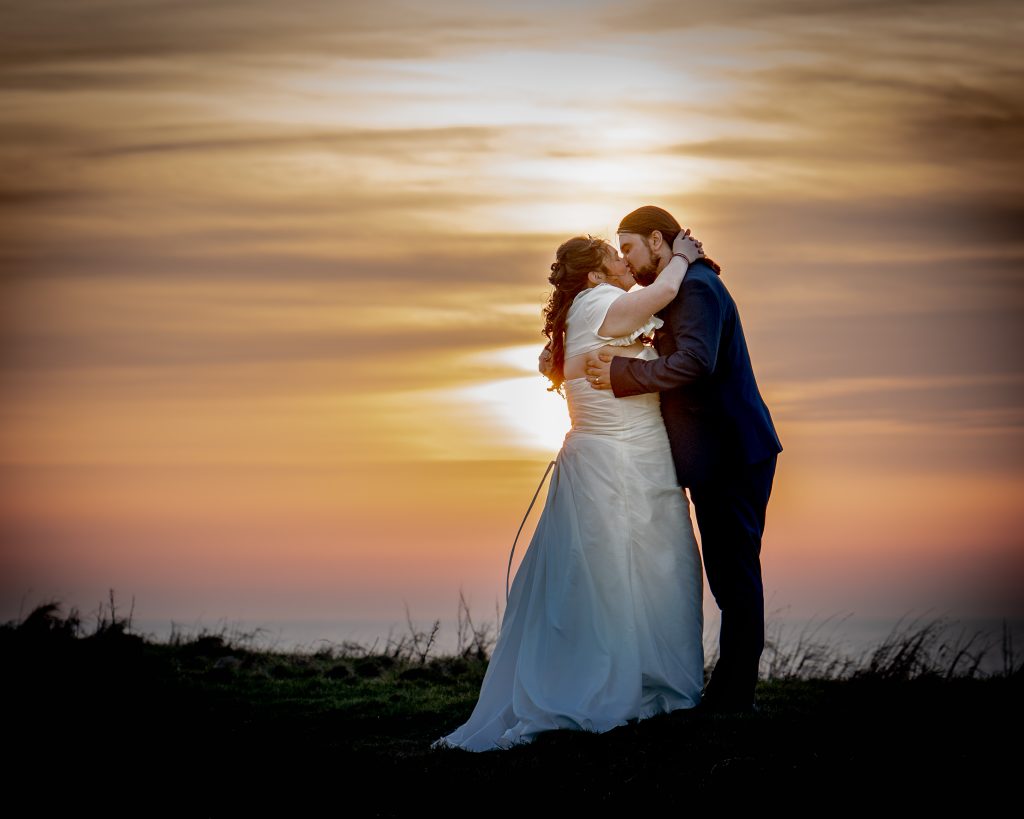 Bride and Groom kissing in the sunset